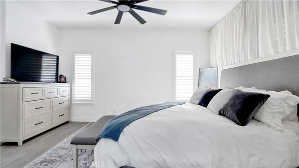 a bedroom with a bed and a flat tv screen on wall
