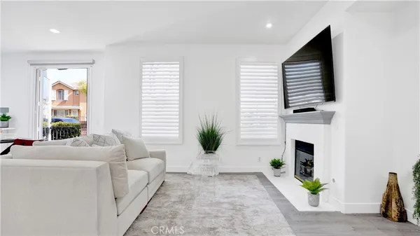 a living room with furniture a fireplace and a potted plant