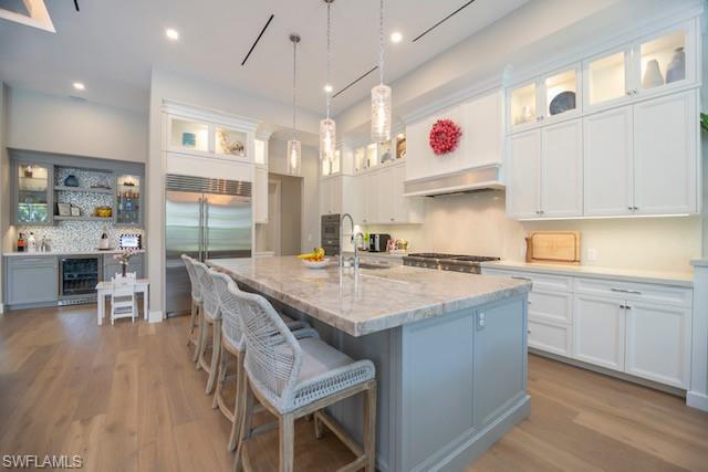 Undisclosed Address Naples, FL 34110 - Photo 6 of 18 a kitchen with stainless steel appliances granite countertop a sink stove and wooden cabinets with wooden floor