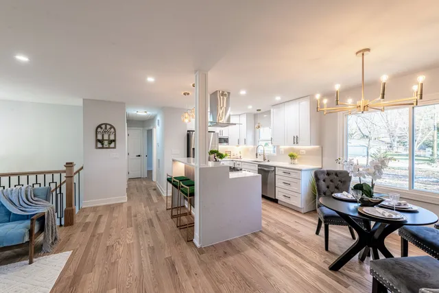 a living room with furniture a wooden floor and kitchen view