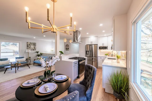 a kitchen with stainless steel appliances wooden floor dining table and chairs