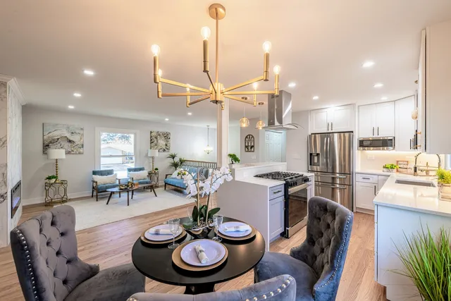 a kitchen with stainless steel appliances kitchen island granite countertop a dining table and chairs