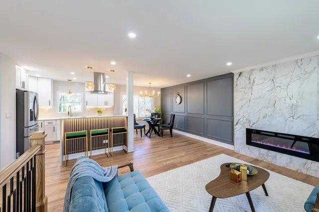 a living room with furniture a dining table and kitchen view with wooden floor