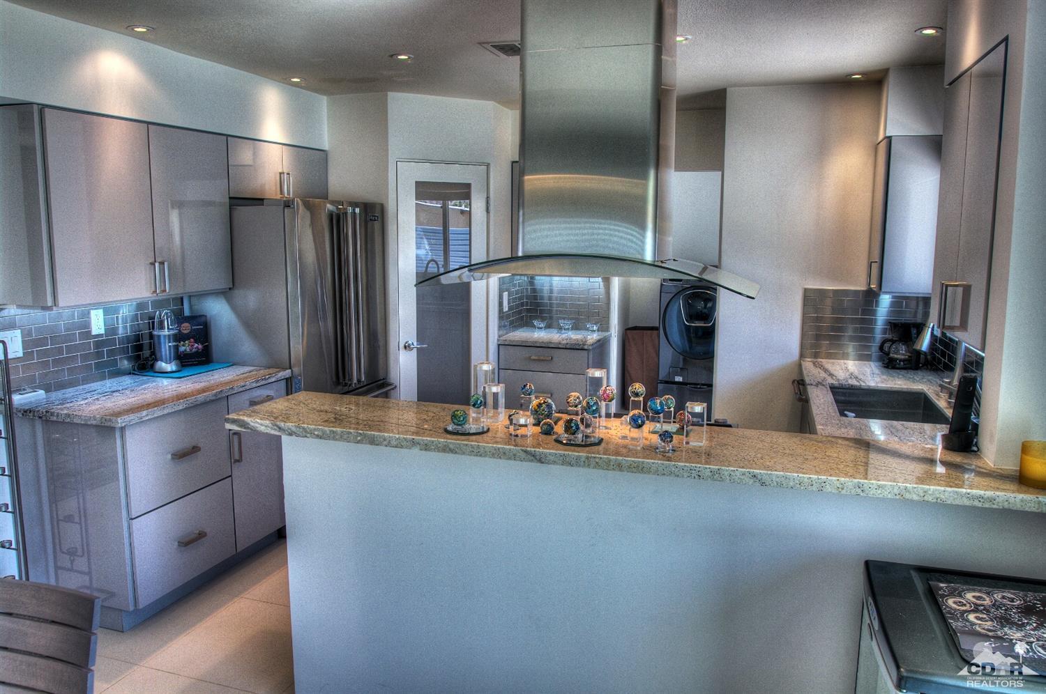 465 East Simms Road Palm Springs, CA 92262 - Photo 17 of 41 a kitchen with stainless steel appliances kitchen island granite countertop a sink and cabinets