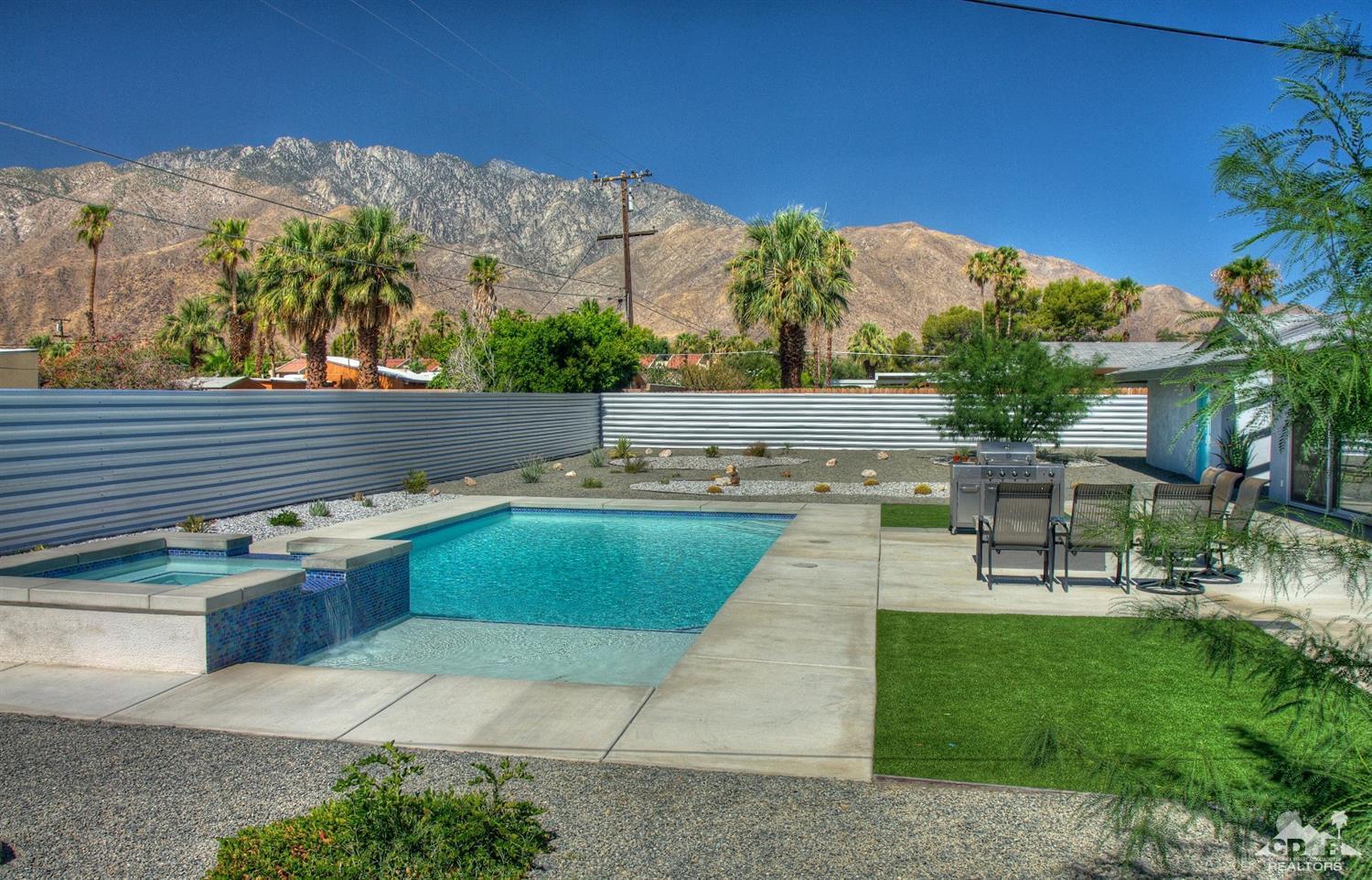 465 East Simms Road Palm Springs, CA 92262 - Photo 31 of 41 a view of a swimming pool with lawn chairs under an umbrella