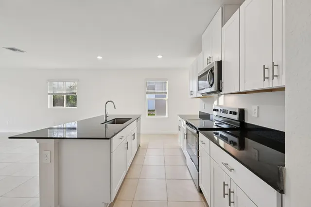 a kitchen with granite countertop a sink and cabinets