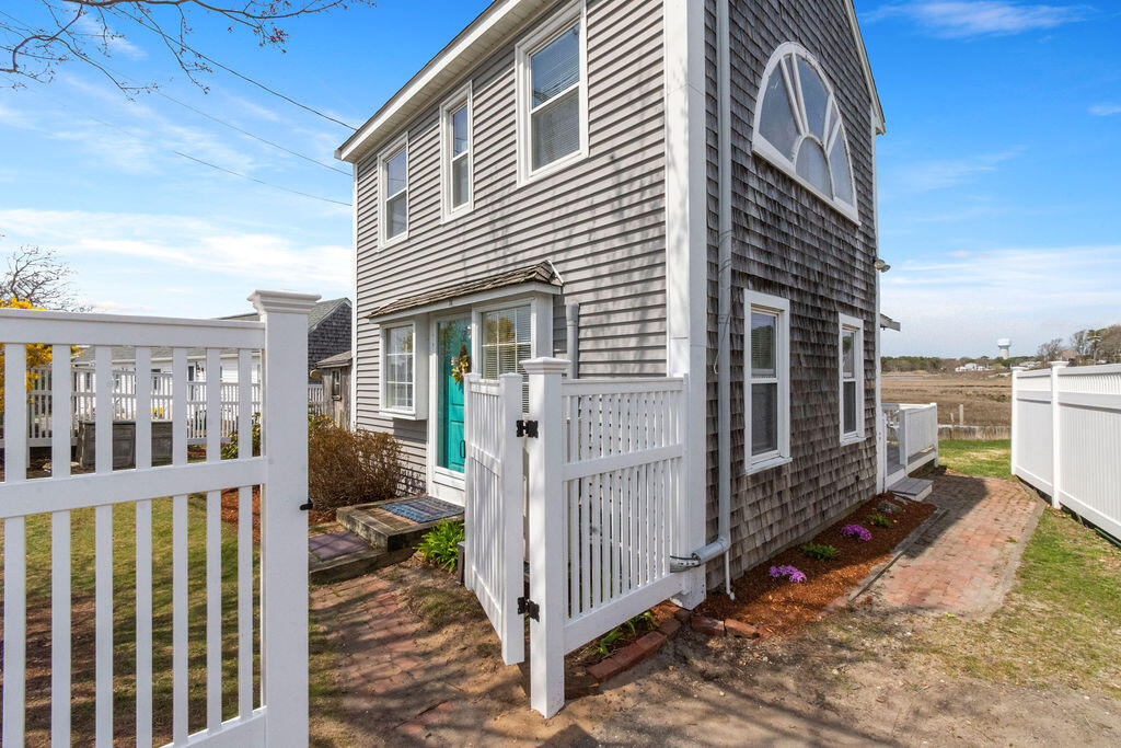 14 Lower County Road Dennis Port, MA 02639 - Photo 5 of 56 a view of a house with a small yard and wooden fence