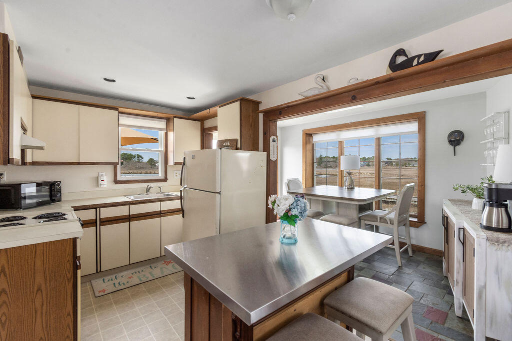 14 Lower County Road Dennis Port, MA 02639 - Photo 10 of 56 a kitchen with a refrigerator a stove a sink dishwasher and white cabinets with wooden floor