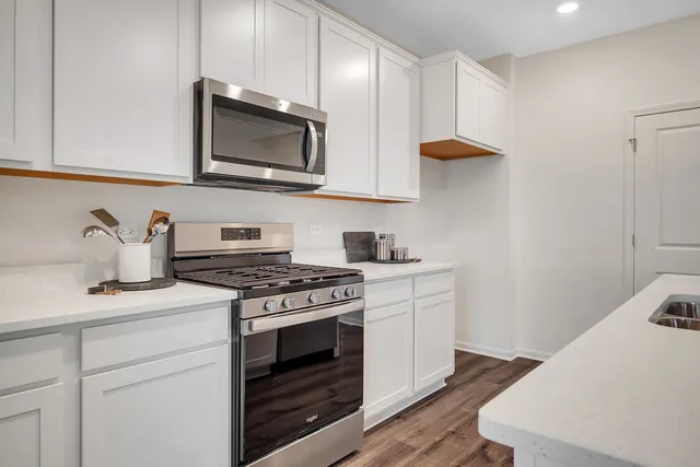 a kitchen with stainless steel appliances a sink a stove and a microwave