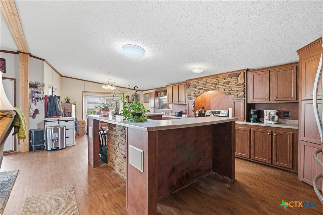 164 County Road 4450 Kempner, TX 76539 - Photo 27 of 42 a kitchen with stainless steel appliances a refrigerator a sink dishwasher a oven with white cabinets and wooden floor
