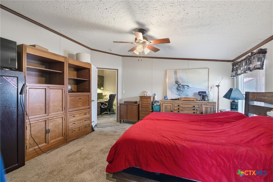 164 County Road 4450 Kempner, TX 76539 - Photo 38 of 42 a bedroom with a large bed and a chandelier