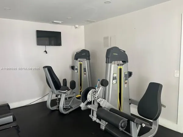 a view of a workspace with furniture and a flat screen tv