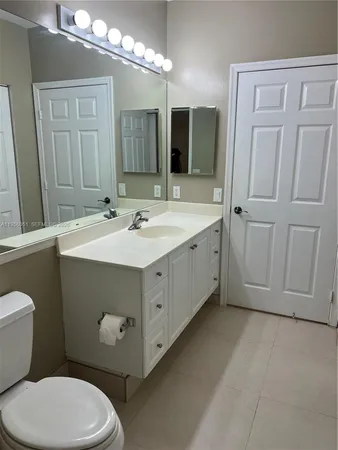 a bathroom with a toilet sink double vanity and mirror