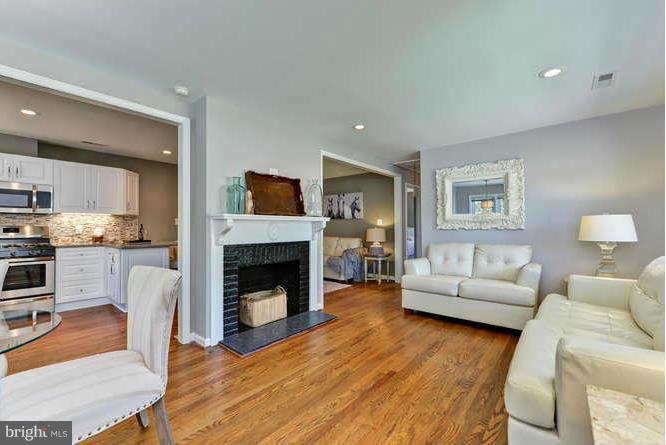 7923 Fairfax Road Alexandria, VA 22308 - Photo 3 of 29 a living room with furniture a fireplace and a wooden floor