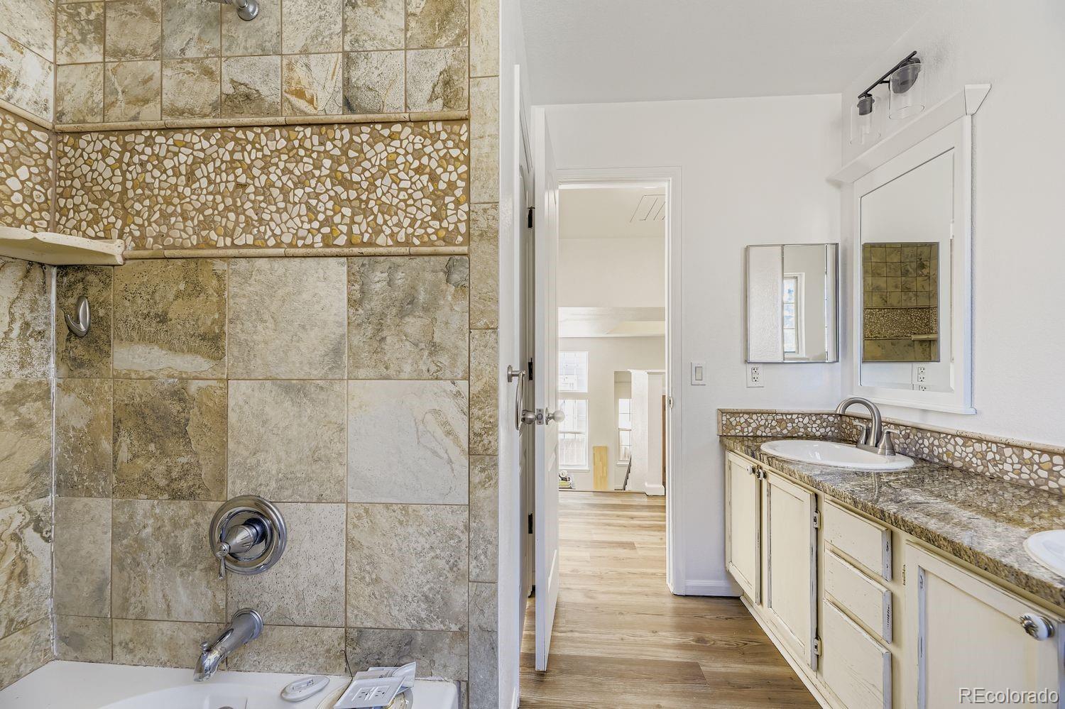13073 South Stuart Way Parker, CO 80134 - Photo 11 of 23 a bathroom with a granite countertop shower a sink and a mirror