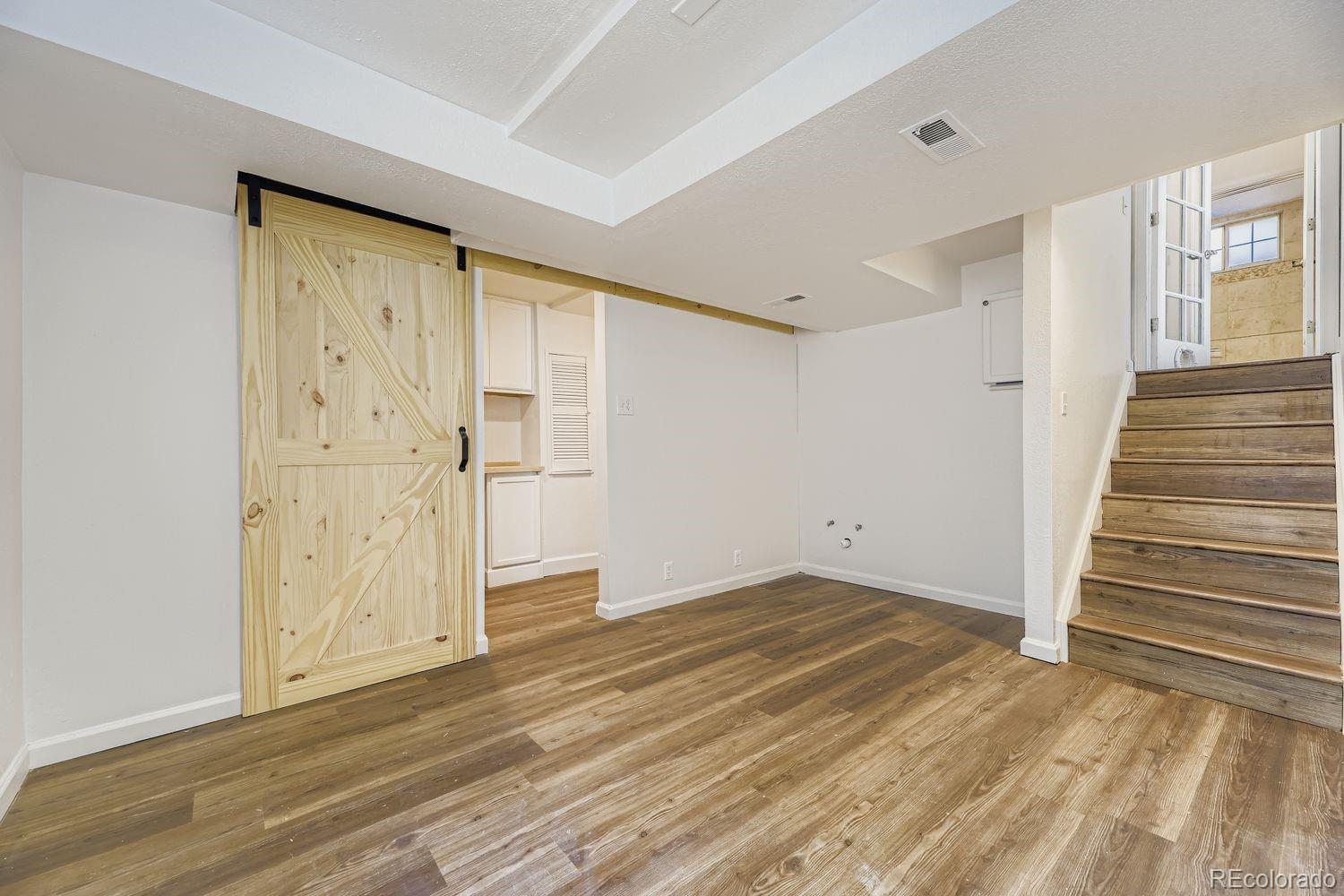 13073 South Stuart Way Parker, CO 80134 - Photo 14 of 23 a view of an empty room with wooden floor and entryway
