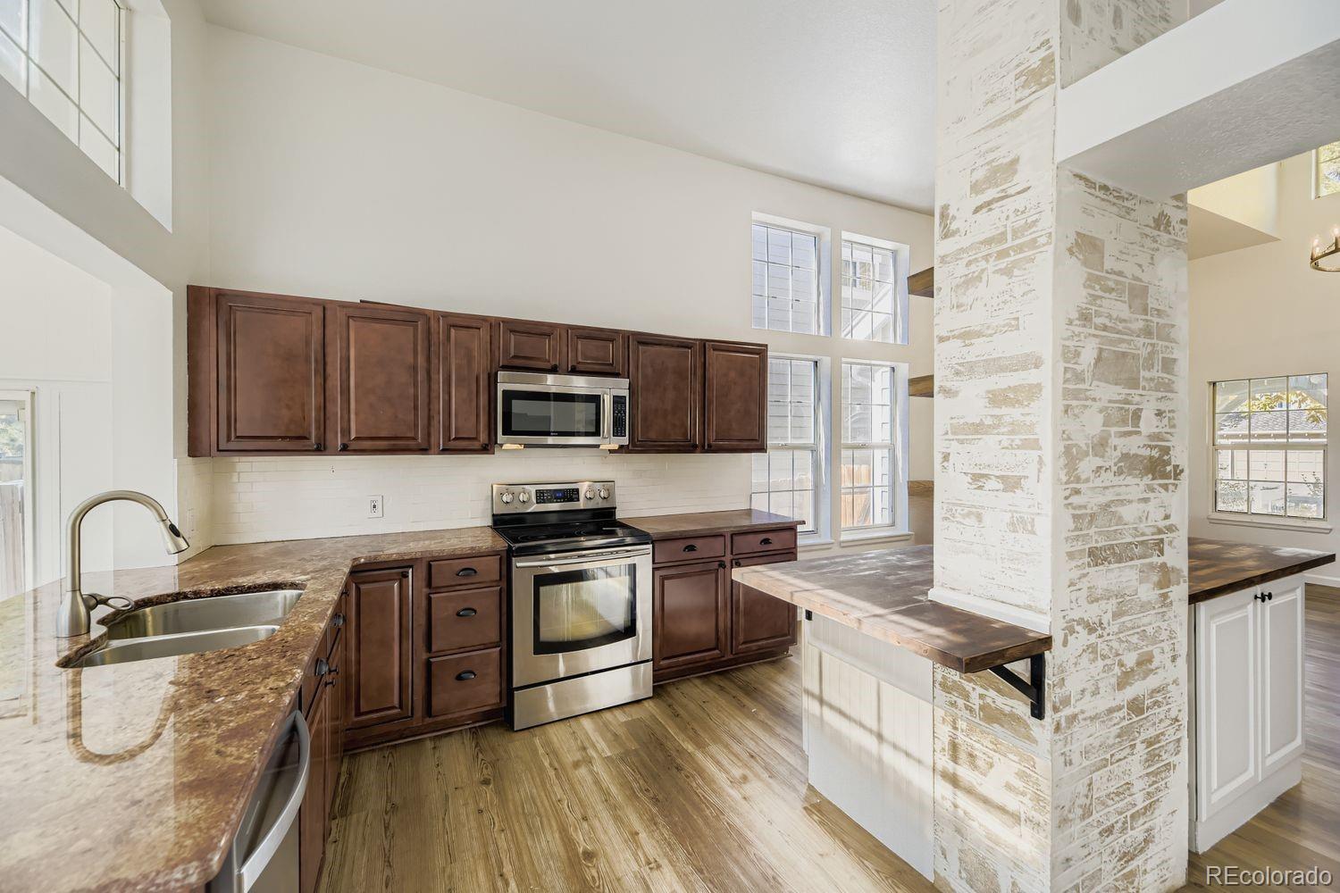 13073 South Stuart Way Parker, CO 80134 - Photo 5 of 23 a kitchen with stainless steel appliances granite countertop a stove and a sink