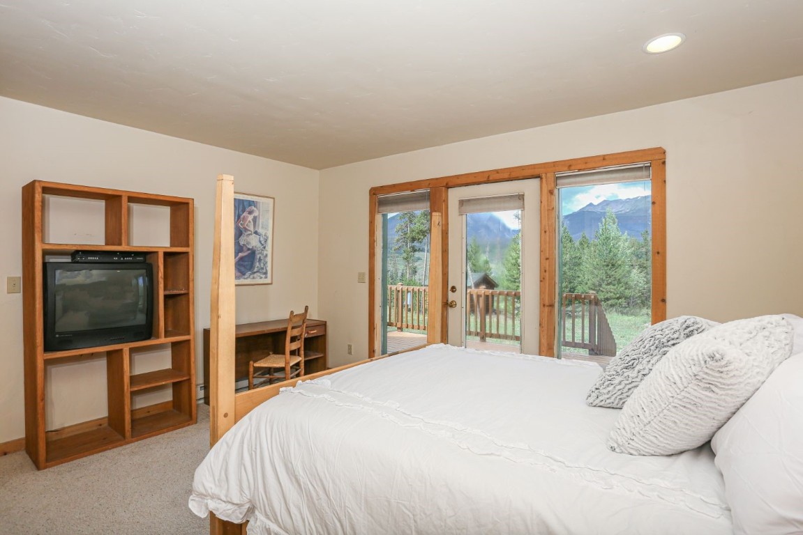 26 Raspberry Lane Silverthorne, CO 80498 - Photo 23 of 35 a bedroom with a large bed and a flat tv screen