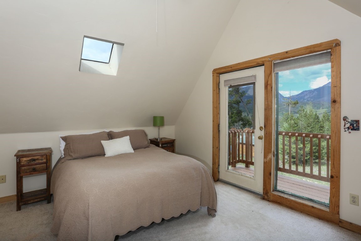 26 Raspberry Lane Silverthorne, CO 80498 - Photo 33 of 35 a bedroom with a large bed and a lamp next to a window