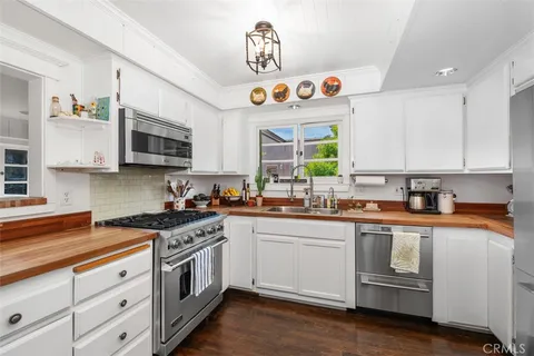 a kitchen with cabinets appliances a sink and a window
