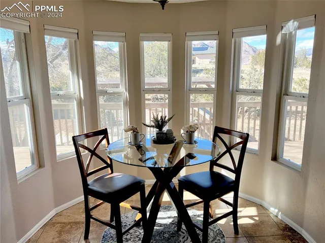 a dining hall with granite countertop a sink dishwasher a dining table and chairs with wooden floor