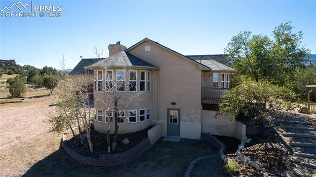 a view of a house with a yard and potted plants