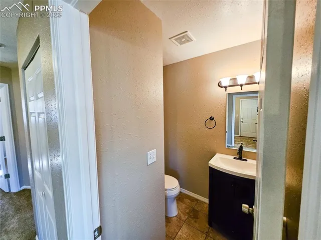 a view of a hallway with wooden floor and a living room