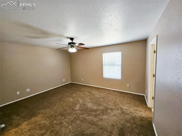 an empty room with closet and a chandelier fan