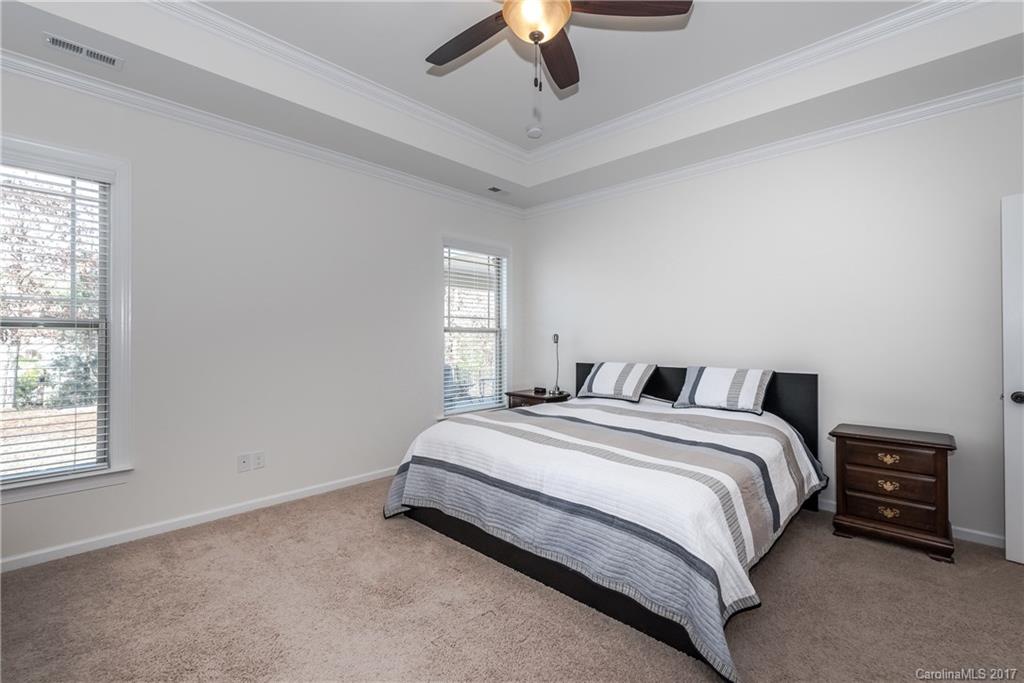 541 Brookhaven Drive, Unit 76 Fort Mill, SC 29708 - Photo 12 of 24 a spacious bedroom with a bed and a chandelier