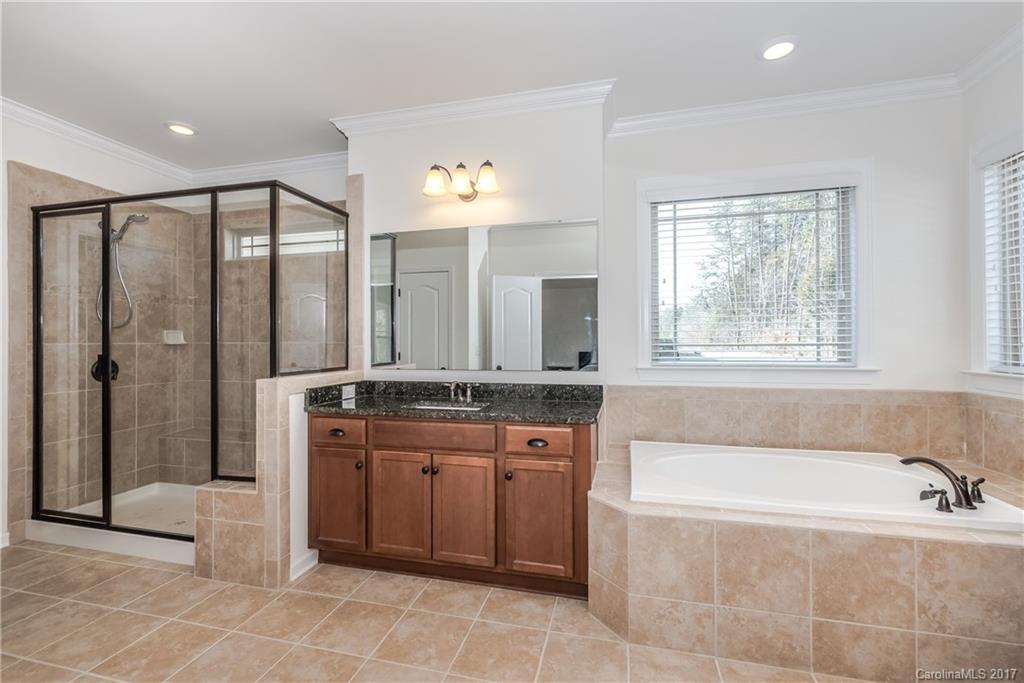 541 Brookhaven Drive, Unit 76 Fort Mill, SC 29708 - Photo 14 of 24 a spacious bathroom with a granite countertop tub sink shower and mirror