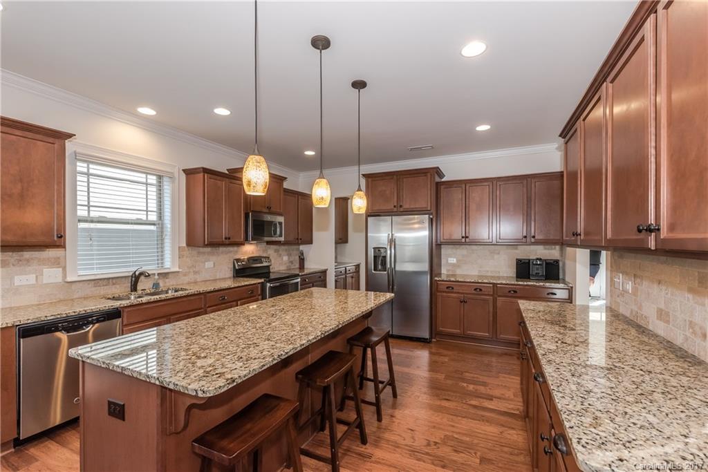 541 Brookhaven Drive, Unit 76 Fort Mill, SC 29708 - Photo 6 of 24 a kitchen with stainless steel appliances granite countertop a kitchen island a stove and a sink