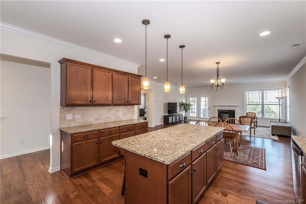 541 Brookhaven Drive, Unit 76 Fort Mill, SC 29708 - Photo 8 of 24 a kitchen with a stove center island cabinets and wooden floor