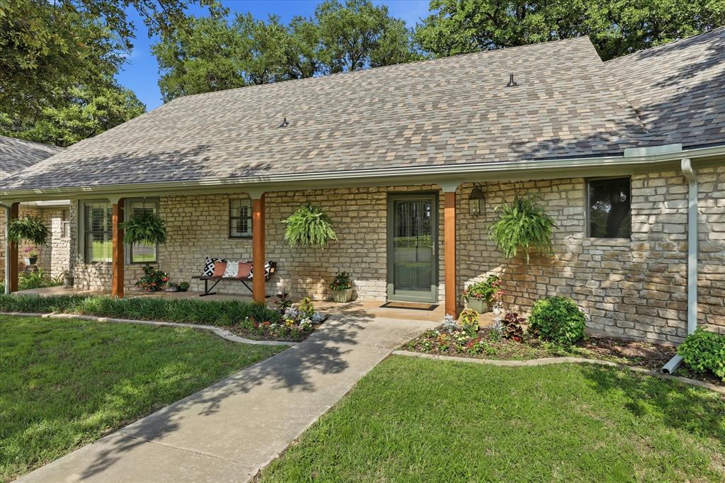 1904 Oak Ridge Trail Bridgeport, TX 76426 - Photo 1 of 40 a front view of a house with garden and porch