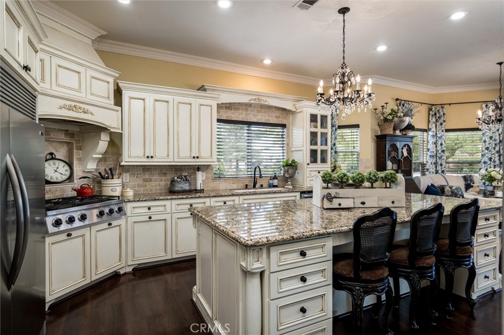 14787 Wood Road Riverside, CA 92508 - Photo 13 of 64 a kitchen with stainless steel appliances granite countertop a stove top oven a sink dishwasher and white cabinets with wooden floor