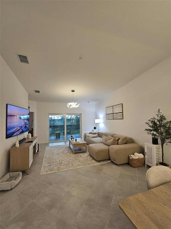 17470 Opal Sand Drive, Unit 201 Venice, FL 34293 - Photo 11 of 49 a living room with furniture and a flat screen tv