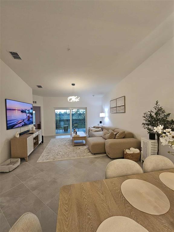 17470 Opal Sand Drive, Unit 201 Venice, FL 34293 - Photo 13 of 49 a living room with furniture and a flat screen tv