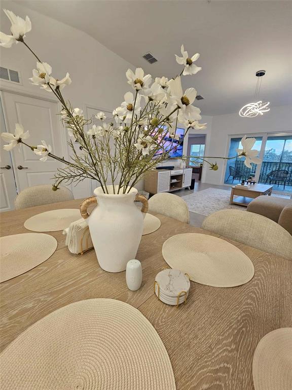 17470 Opal Sand Drive, Unit 201 Venice, FL 34293 - Photo 15 of 49 a dining room with furniture and a chandelier