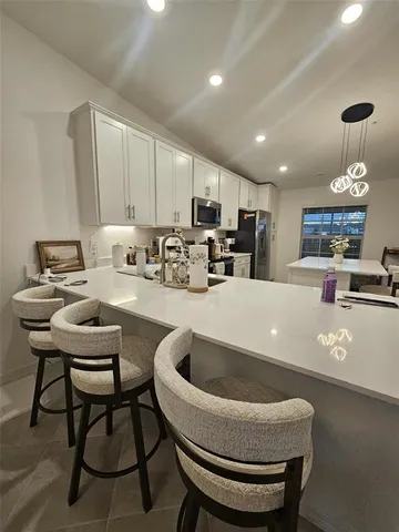 a kitchen with a refrigerator a sink and cabinets