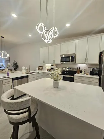a living room with kitchen couches and a dining table with wooden floor