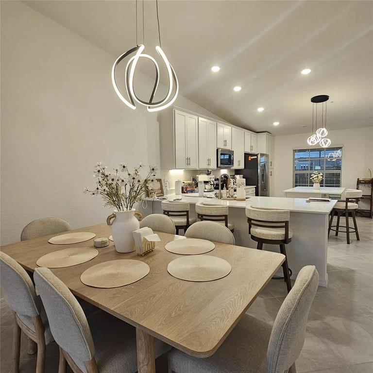 17470 Opal Sand Drive, Unit 201 Venice, FL 34293 - Photo 21 of 49 a living room with kitchen couches and a dining table with wooden floor