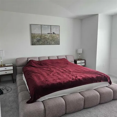 a spacious bedroom with a bed and window
