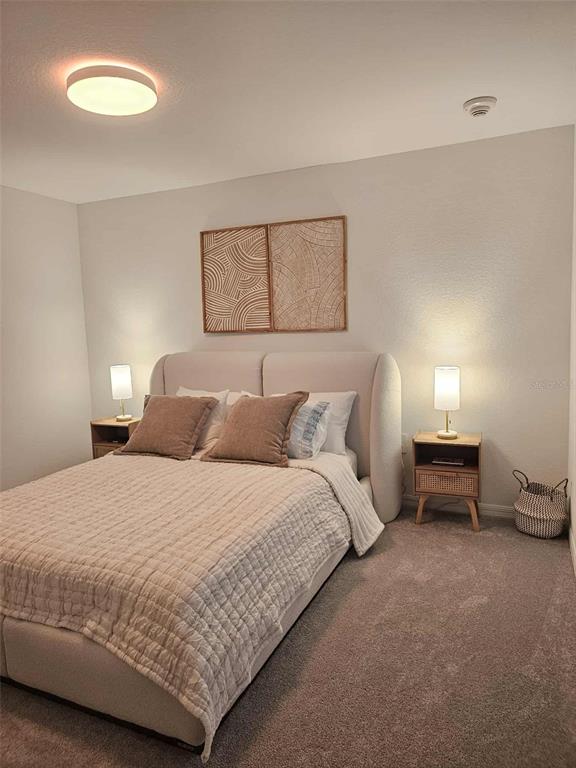 17470 Opal Sand Drive, Unit 201 Venice, FL 34293 - Photo 31 of 49 a bedroom with a bed and a night stand