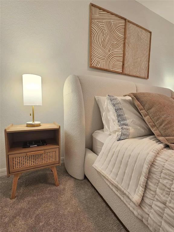 17470 Opal Sand Drive, Unit 201 Venice, FL 34293 - Photo 35 of 49 a bedroom with a bed and a night stand