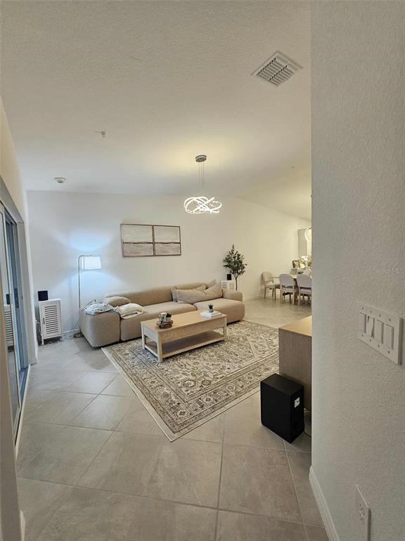 17470 Opal Sand Drive, Unit 201 Venice, FL 34293 - Photo 4 of 49 a living room with furniture and a flat screen tv