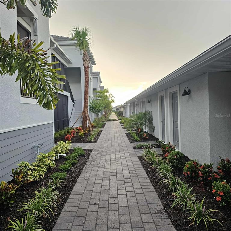 17470 Opal Sand Drive, Unit 201 Venice, FL 34293 - Photo 48 of 49 a view of a pathway with house on both side