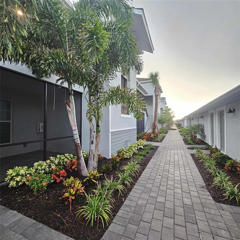 17470 Opal Sand Drive, Unit 201 Venice, FL 34293 - Photo 49 of 49 a view of a pathway that has potted plants