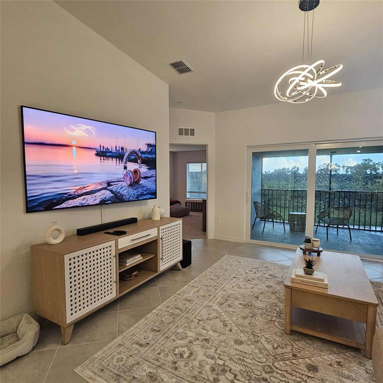 17470 Opal Sand Drive, Unit 201 Venice, FL 34293 - Photo 7 of 49 a living room with furniture and a flat screen tv