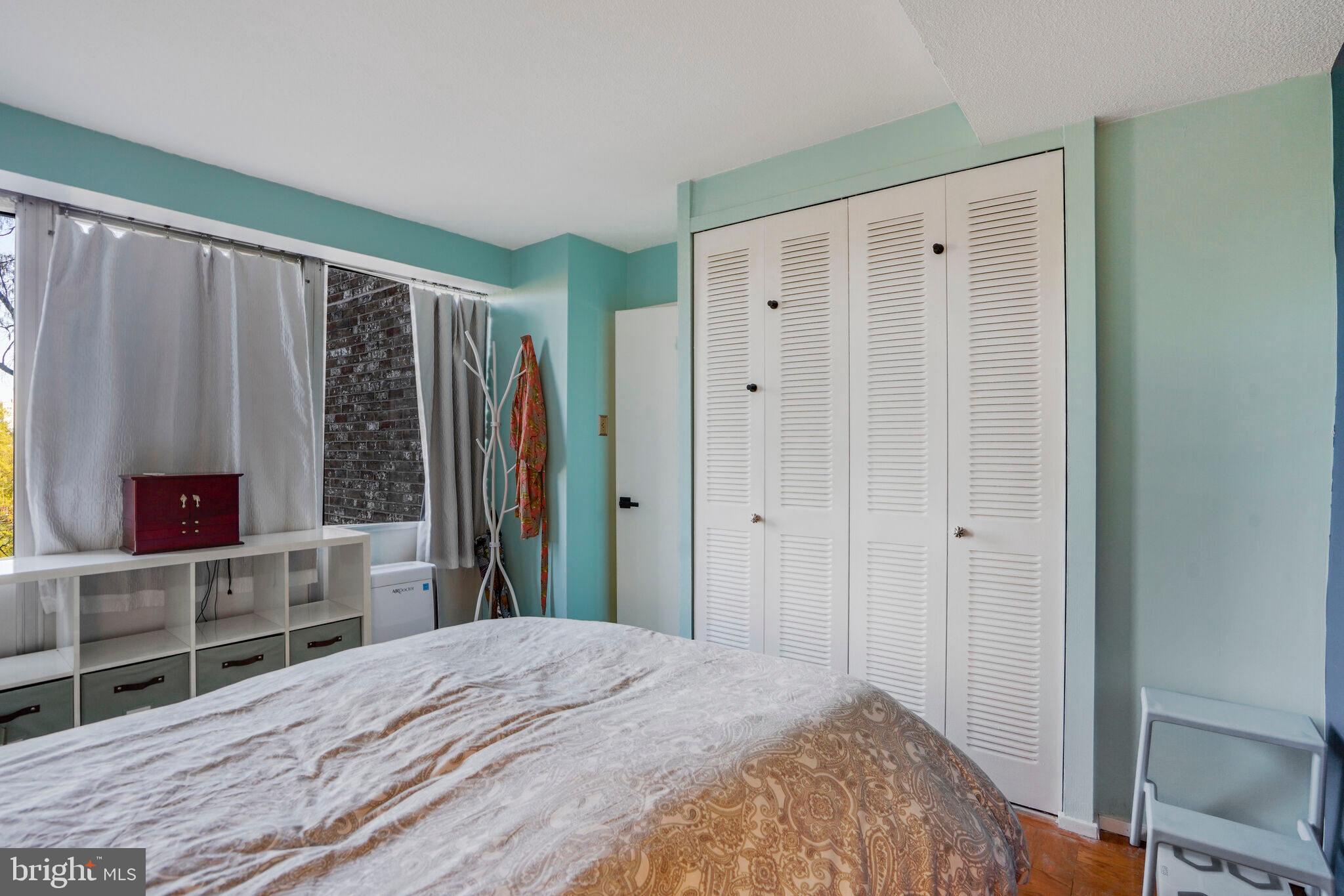 1301 Delaware Avenue Southwest, Unit N514 Washington, DC 20024 - Photo 12 of 44 a bedroom with a bed and a flat tv screen in it