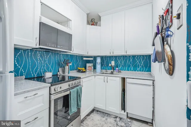 a kitchen with stainless steel appliances cabinets and wooden floor