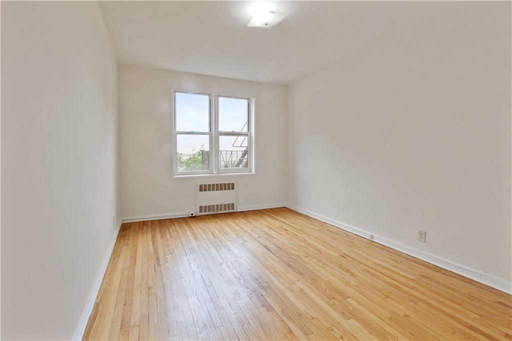6801 Shore Road, Unit 5U Brooklyn, NY 11220 - Photo 12 of 21 an empty room with wooden floor and windows